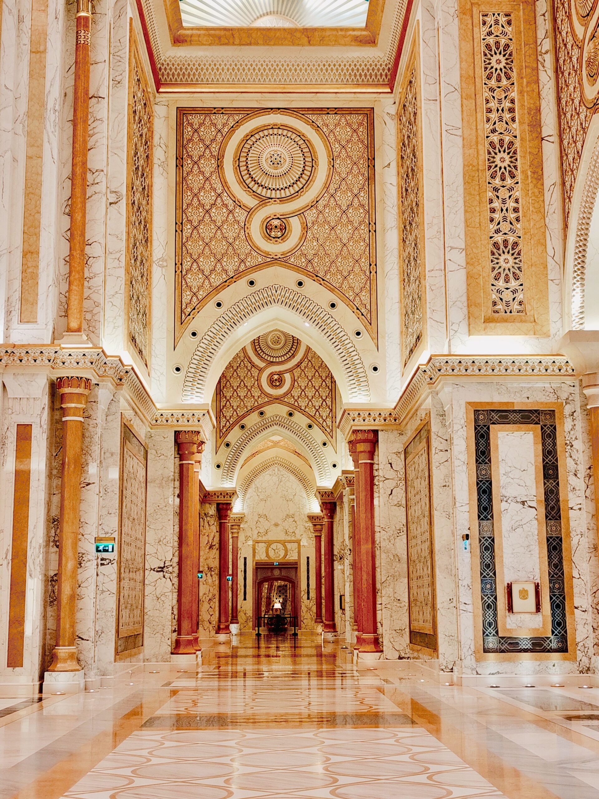 Luxurious indoor corridor with arches and marble details showcasing intricate patterns and decorations.